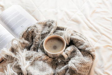 Hot drink on a shawl and open book