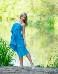 Beautiful young girl in a dress walking in the summer Park