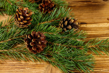 Christmas composition with fir tree branches and cones on wooden background
