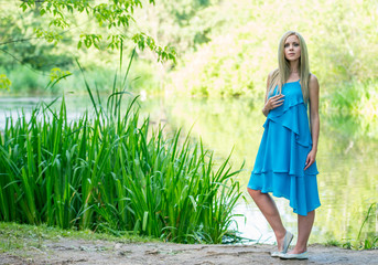 Beautiful young girl in a dress walking in the summer Park