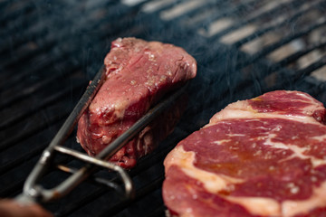Steak and rib are cooking on grill. Pork ribs and steak on hot grill. Restaurant kitchen, culinary.