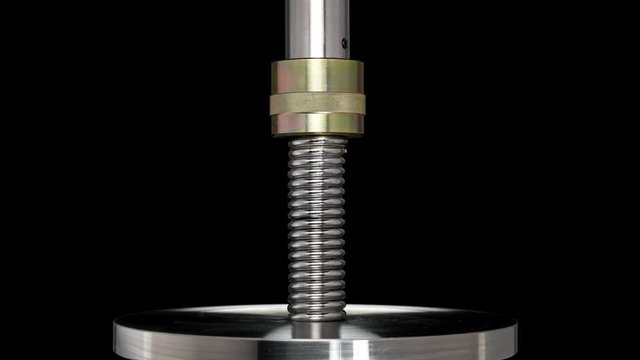 test of reliability of a spring, compression and decompression by a hydraulic press, close-up