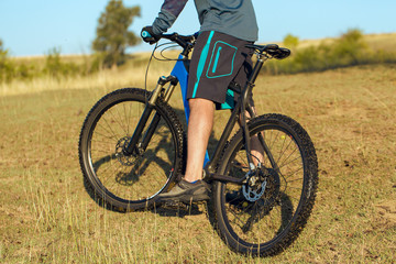 Naklejka premium A cyclist rides the hills, Beautiful portrait of a guy on a blue bicycle