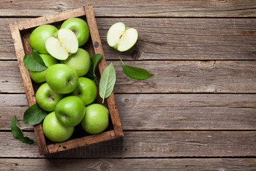 Green apples in wooden box