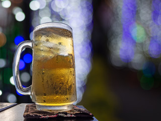 glass of beer on blurred christmas background with light bokeh