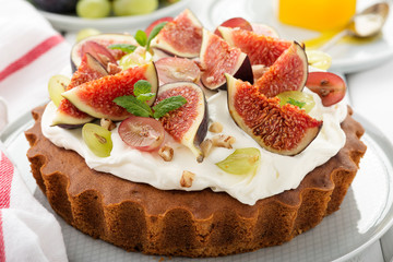 Delicious creamy tart cake with fresh figs and grape.