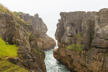 Fototapeta na wymiar High cliffs in bay, rocks with texture