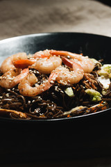 Delicious meal with shrimps in black plate, traditional Aisan food