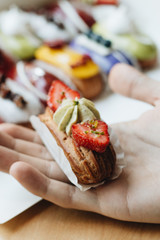 Male hand taking delicious sweets with glaze, colorful dessert