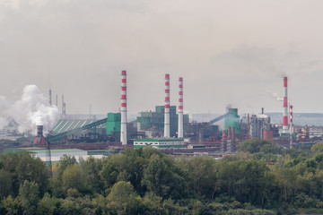 Fototapeta na wymiar Coal processing plant operates on the river bank. Smoke from the pipes pollutes the atmosphere of the city. Concept of pollution of the environment, emissions into water resources. Industrial landscap
