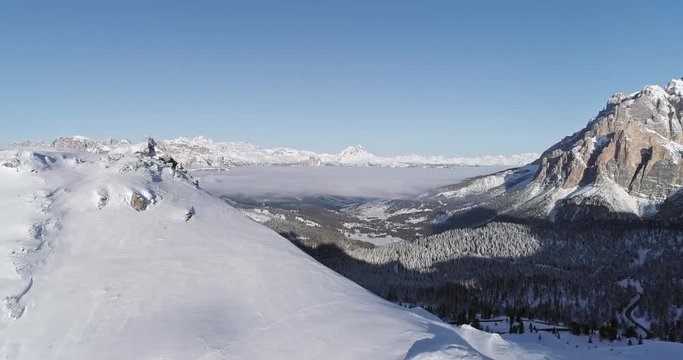 Forward aerial to snowy alpine valley with woods forest at Valparola pass.Sunny sunset or sunrise,clear sky.Winter Dolomites Italian Alps mountains outdoor nature establisher.4k drone flight