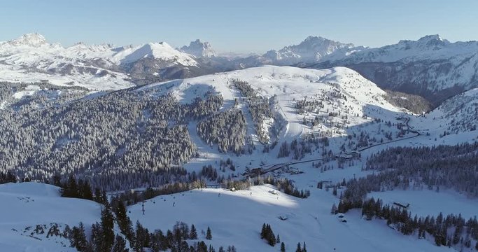Forward aerial to snowy alpine valley with ski tracks, chair lifts at Piz Boe.Sunny day,clear sky.Winter Dolomites Italian Alps mountains outdoor nature establisher.4k drone flight