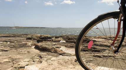 silueta de bicicleta al atardecer y por la mañana con horizonte marítimo de fondo.