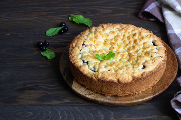 Homemade shortcrust fruit or jam pie with crumble and fresh berries with mint on old wooden table background. Homemade pastry with fruit or berry (cherry, plum, strawberry, raspberry) jam.