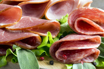 slices of French cheese-dried salami with spices on wooden background