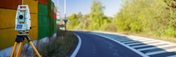 Panoramic view of surveyor equipment (theodolite or total positioning station) on the construction site of the motorway or road
