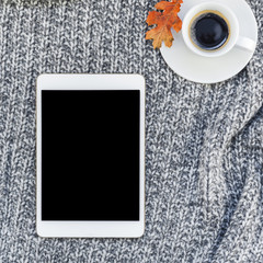 Home workplace with coffee cup on knitted plaid