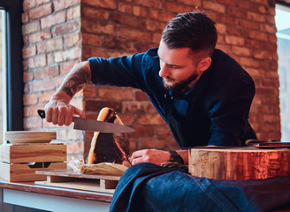 Chef cook cutting exclusive jerky meat on table in a kitchen with loft interior.