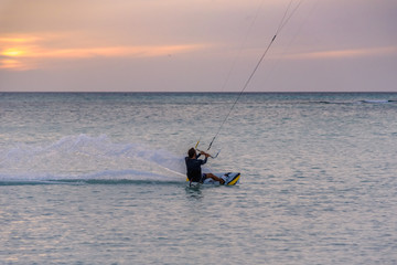 A man does acrobatics while kitesurfing