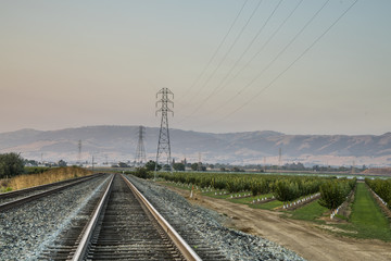 Fototapeta na wymiar Train Rail Crossing the Countryside Farms