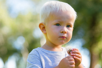 Wonderful kid. Unusual sweet kid looking aside while spending time in the garden