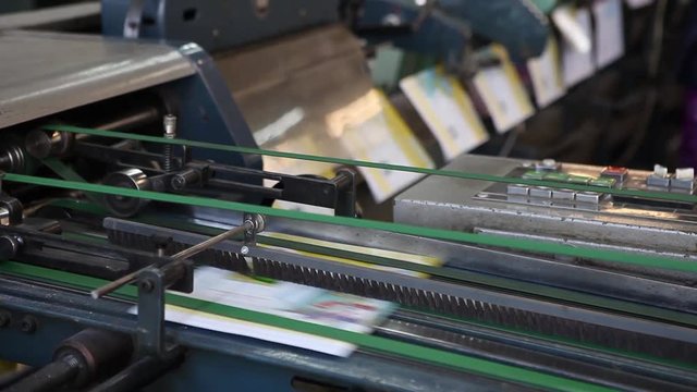 Video clip from the printing factory. Production of magazines and school atlases. Printed products on the conveyor belt