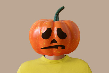 Portrait of a man with a pumpkin instead of a head. Halloween minimal concept.