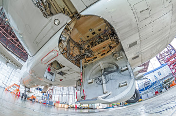 Aviation hangar with airplane, close-up landing gear of the airplane landing gear on maintenance repair.