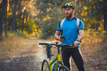 Naklejka premium bearded man cyclist rides in the forest on a mountain bike.