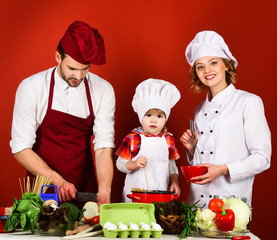 Happy loving family preparing dinner together. Parents little helper concept. Chef man&woman cooking on kitchen with little son. Happy family, parenting concept. Family healthy dinner. Cooking at home