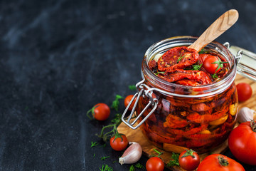 Sun dried tomatoes with garlic and olive oil in a jar