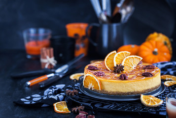 Delicious pumpkin and orange cheesecake decorated with caramel sauce and pecan