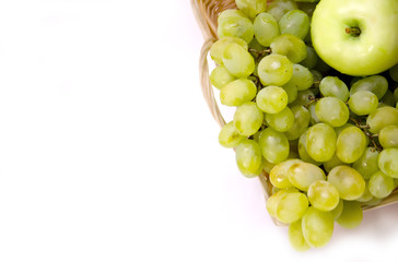green grapes in the basket and the Apple on white background selective focus