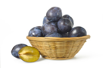 Plums in the basket isolated on white background