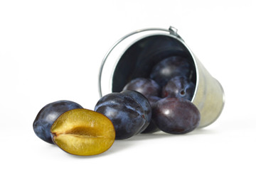 Plums in the bucket isolated on white background