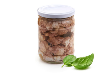 Canned meat in a glass jar with basil leaf, isolated on white background.