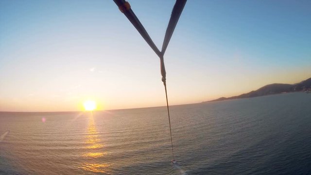 Parachute flight tied to a boat over the Black Sea in a beautiful sunset, first-person view, extreme entertainment