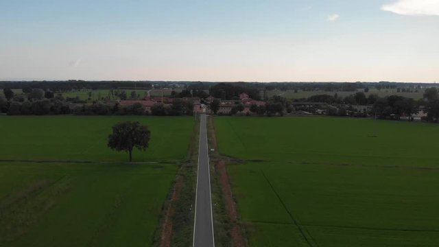 Flight over country road with villa and fields
