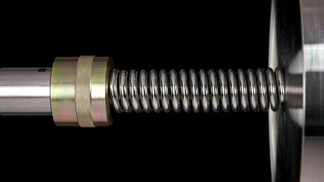 test of reliability of a spring, compression and decompression by a hydraulic press, close-up