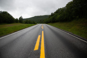 A Road in Norway heading between two hills.