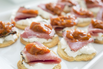 Canape with smoked meat, cheese and tomato sauce