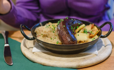 Traditional austrian dish blood sausage with sauerkraut and fries