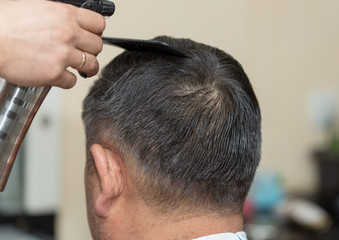 Fototapeta premium Hairdresser cuts hair