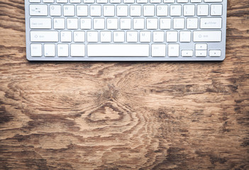 White computer keyboard on wooden background.