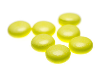 bottle of yellow medical valerian pills on a white background, herb medicine