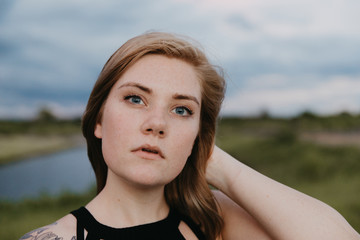 Cute Young Female Model with Short Hair and Freckles Modeling in a Bare Field