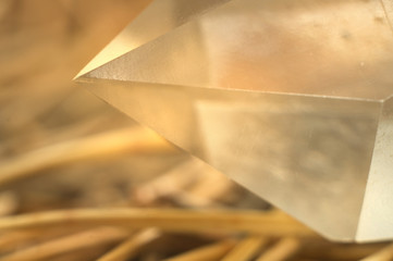 Sharp top point of faceted gem crystal quartz on natural background of needles closeup macrophotography
