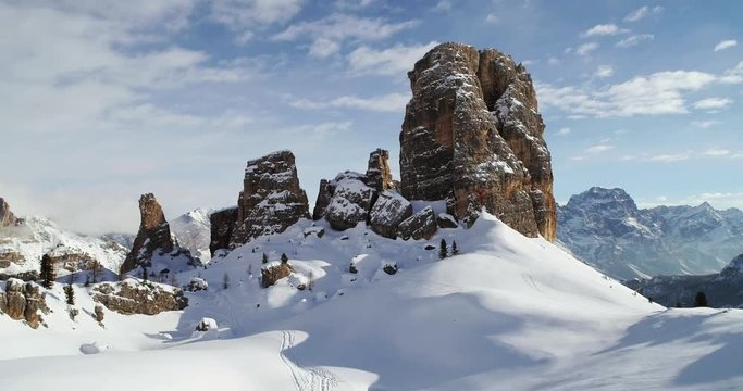Forward aerial toward majestic Cinque Torri rocky mounts tilting up. Sunny day with cloudy sky.Winter Dolomites Italian Alps mountains outdoor nature establisher.4k drone flight