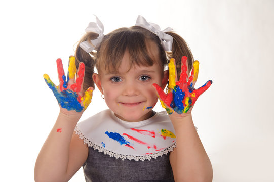 Little girl with hands covered in finger paint after painting a picture
