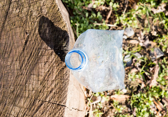 Shredded plastic mineral water bottles and bottle caps on the grass in the park, the concept of environmental protection, environmental protection clogging